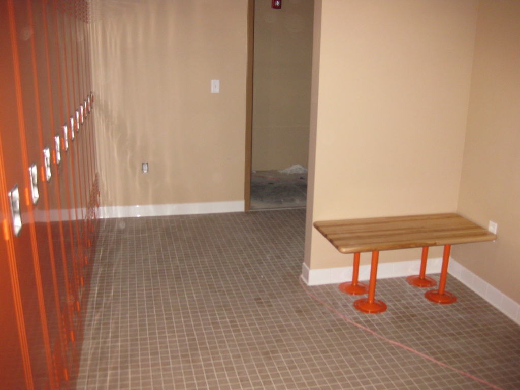 Metro Logics locker room with orange lockers and changing bench
